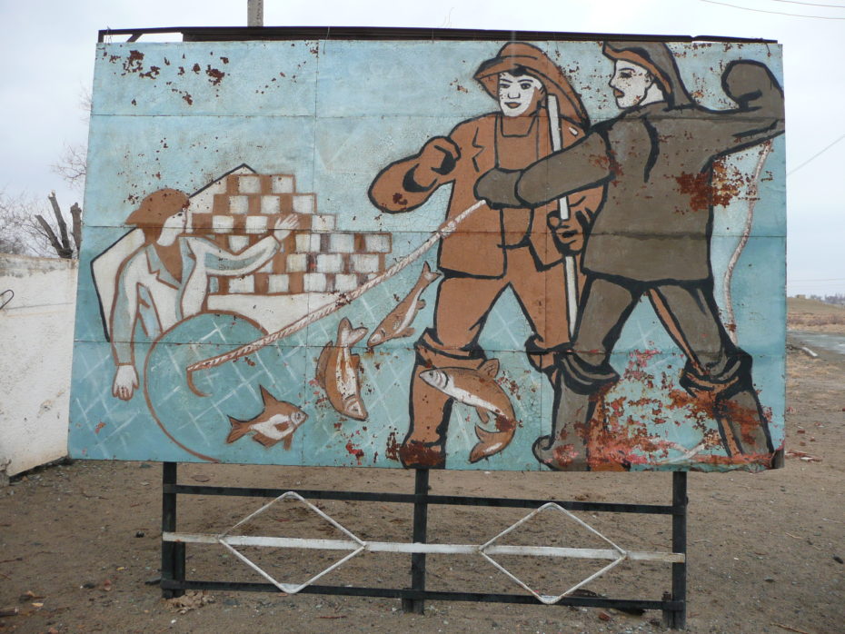 Sign at the factory entrance depicting the noble toil of fishermen and can stackers