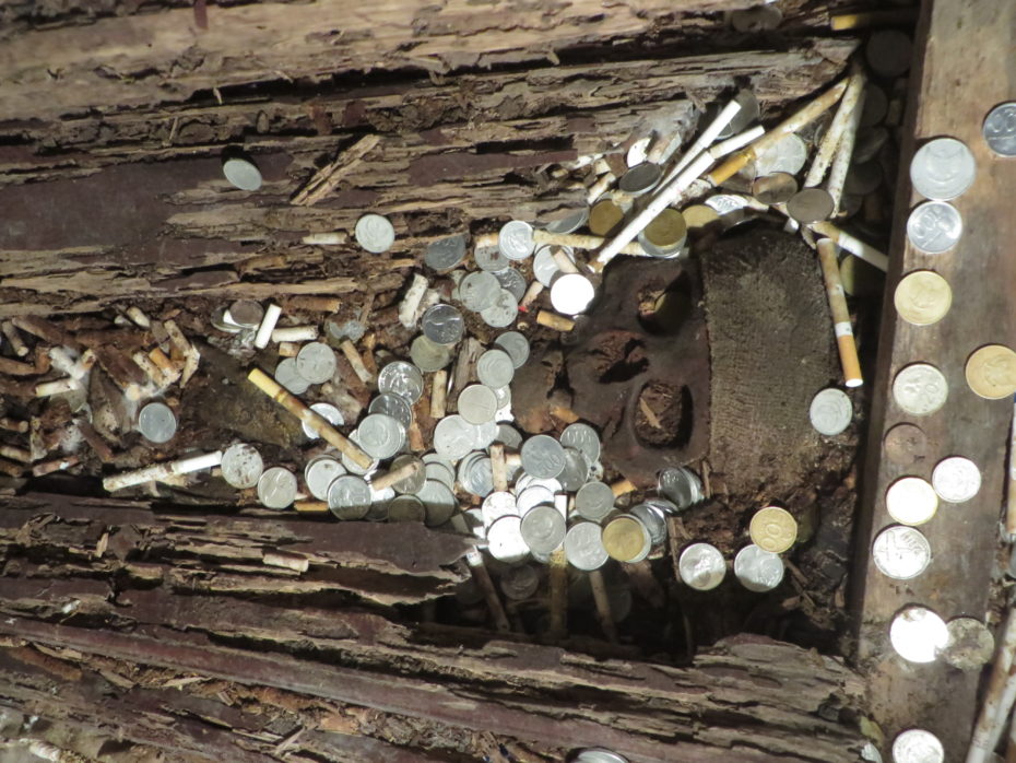 Offerings such as money and cigarettes are still left to find favor with the ancestors